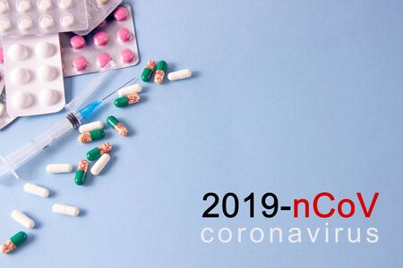 Coronavirus phrase text on a blue background with medicines and a syringe. New Coronavirus, MERS-Cov Middle East Respiratory Syndrome Coronavirusの写真素材