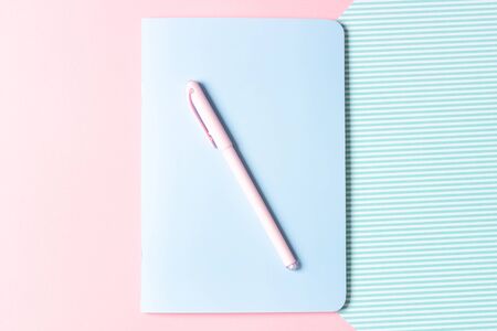 Flat lay female workplace. Notebook and pen on a pink background. The design of the blog and social networks.の写真素材