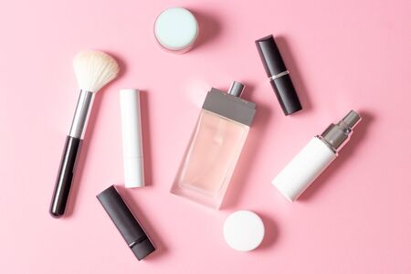 Women's cosmetics and accessories on a pink striped background: perfume, cream, lipstick, makeup brush. Fashion and Beauty Concept.の写真素材
