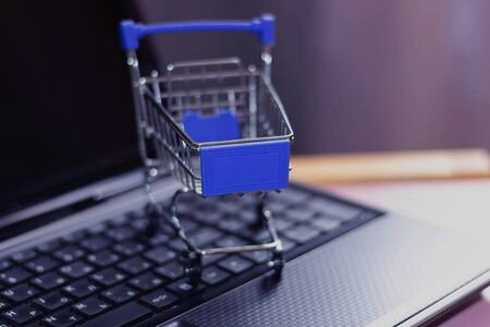 Online shopping with home delivery. Shopping basket on laptop keyboardの写真素材