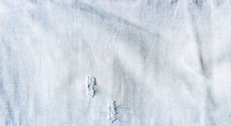 Denim texture. Texture of ripped light blue jeans