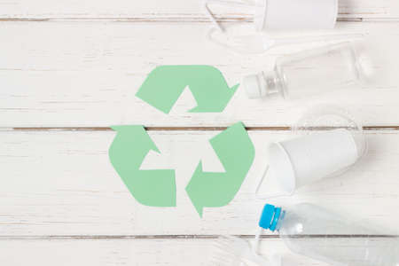 Plastic dishes, bottles, glasses on a white table. Planet pollution