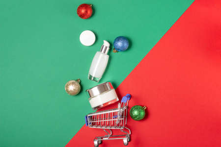 A set of white cosmetic jars lie in a basket on a bright green and red background. Online shopping for home. The concept of buying cosmetics, online shopping, holidayの写真素材