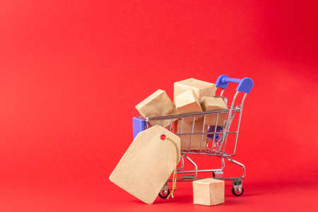 Shopping basket and boxes with purchases with place to add text on a red background. Online shopping...