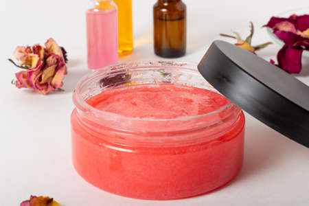 Jar of cosmetic face scrub with rose petals and essential oils. Organic cosmetics. Spa salon, skin careの写真素材