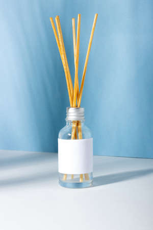 Incense sticks for the home. Blue background with plant shadows and aroma diffuser. Eco-friendly home fragrance conceptの写真素材