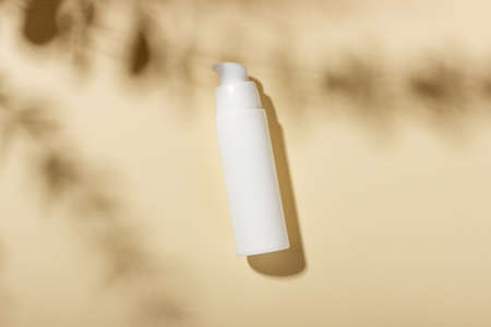 White bottle of moisturizing face and body cream with shadows on the background. Cosmetic spa productの写真素材