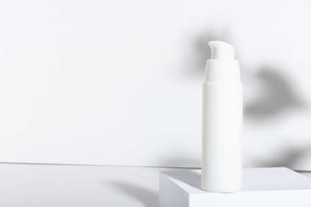 White cosmetic tube for cream, lotion, serum or face mask on the runway with leaf shadows. Professional cosmetics for skin care. Organic cosmetics.の写真素材