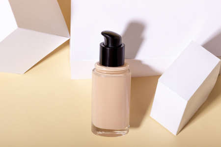 Liquid foundation in a bottle against a background of geometric shapes.の写真素材