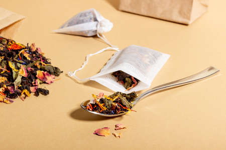 Black tea, herbal and fruit brewed in a transparent cup. Tea for brewing in tea bags. The concept of a natural healthy drink. Tea bags on beige backgroundの写真素材