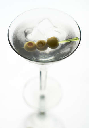 Martini with olive on fancy skewer, isolated on white. の写真素材