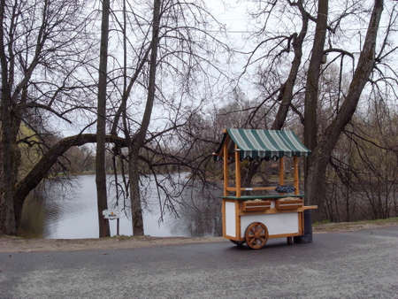 Sale of nuts for visitors. Shopping cart in the park on a background of a pond.の写真素材