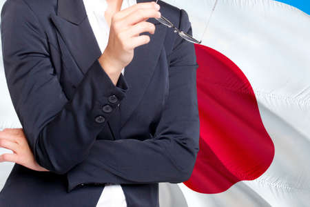 Young woman in a business suit against the background of the Flag of England fluttering in the wind study work businessの写真素材