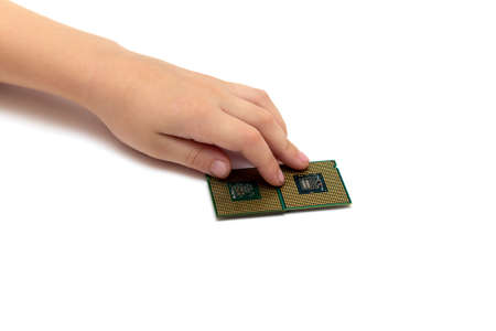 Child hand holds computer central processing units isolated on white background pins up socket 775,...
