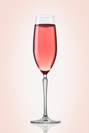 Glass of pink champagne on pink backgroundの写真素材