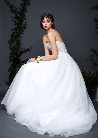 Young bride woman in wedding dress on grey background in the studio with make up and hairstyleの写真素材