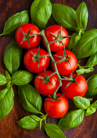 Fresh tomatoes with basil on wooden board. Closeupの写真素材