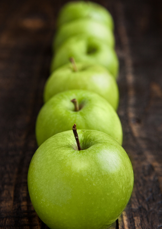 Green organic healthy apples on wooden board. Healthy foodの写真素材