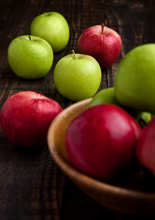 Green and red organic  apples in bowl on wooden board. Healthy foodの写真素材