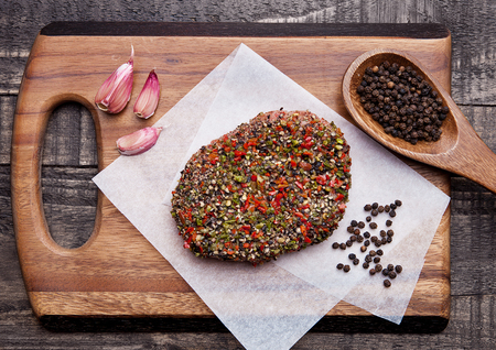 Beef raw steak with pepper and garlic on wooden backgroundの写真素材