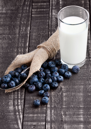 Blueberries  on spoon woth milk glass on wood tale. Still lifeの写真素材