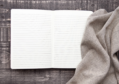 Notebook with kitchen cloth on wooden background. Blank paperの写真素材