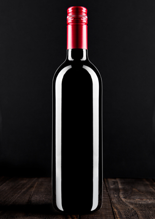 Bottle of red wine dark glass on wooden bacground red topの写真素材