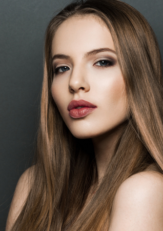 Beautiful woman model portrait with long hair on dark background. Red lipsの写真素材