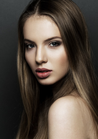 Beautiful woman model portrait with long hair on black background. Red lipsの写真素材