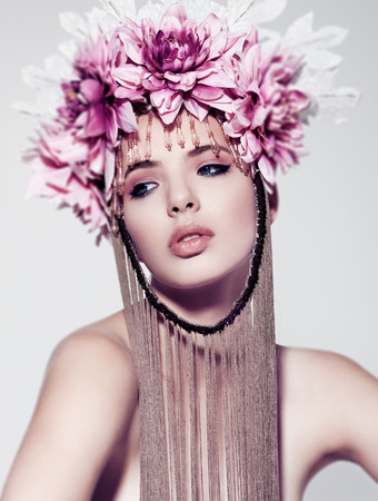 Beautiful woman with flower crown and makeup on white background. Crown with chain belowの写真素材