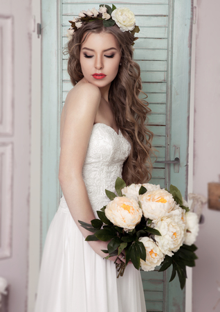 Beautiful young bride with flowers  romantic decoration pink and green. Wooden boxes bottles and different wedding decorationの写真素材