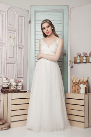 Beautiful young bride in  wedding romantic decoration pink and green. Wooden boxes bottles and different wedding decorationの写真素材