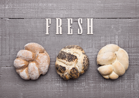 Fresh bread rolls for breakfast morning on wooden table in cafeの写真素材