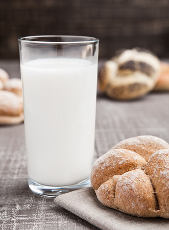 Glass of milk with bread roll for breakfast morningの写真素材