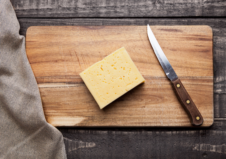Cheese on wooden kitchen board with knife and clothの写真素材