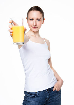 Beautiful woman holding glass with orange juice with white top on white backgroundの写真素材