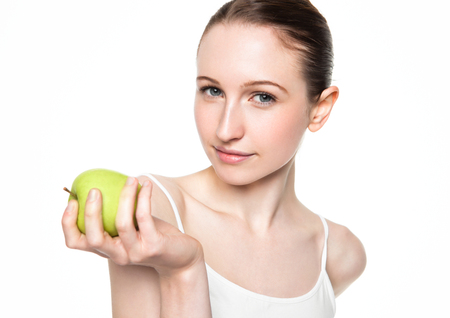 Beautiful fitness woman holding healthy apple on white backgroundの写真素材