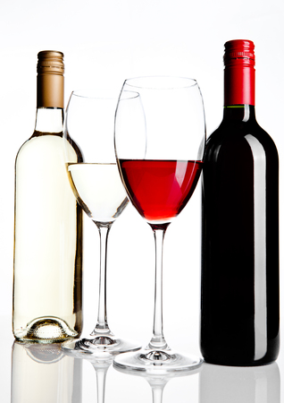 Bottles and glass of red and white wine reflection on white backgroundの写真素材