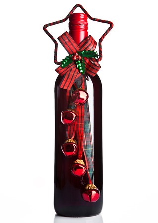 Bottle of red wine with christmas decoration green on white backgroundの写真素材