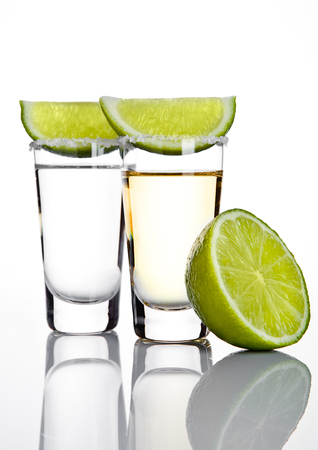Silver tequila shot glass with lime slice and salt on white backgroundの写真素材