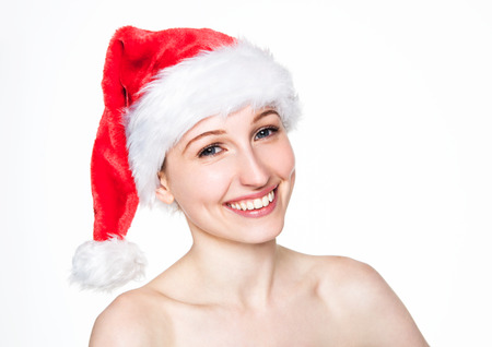 Beautiful woman happy christmas in santa hat holding christmas tree on arm with golden stars on white backgroundの写真素材