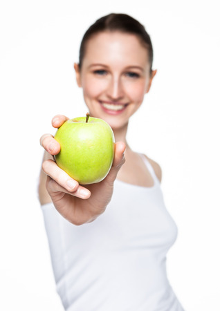 Beautiful fitness woman holding healthy apple on white backgroundの写真素材