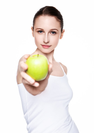 Beautiful fitness woman holding healthy apple on white backgroundの写真素材