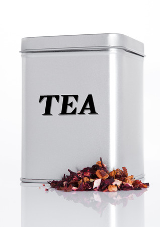 Fruit tea steel jar with loose tea next to it on white backgroundの写真素材