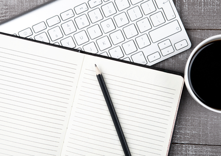 Keyboard with pencil and  coffee cup on office deskの写真素材