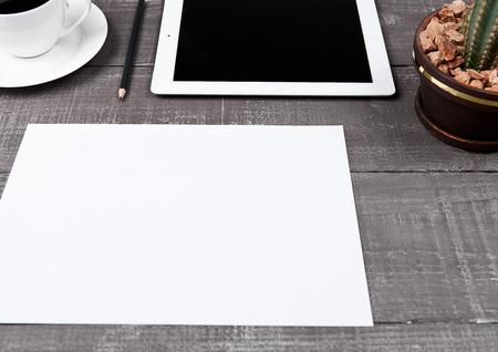 Graphic tablet with cactus paper sheet and coffee on office deskの写真素材
