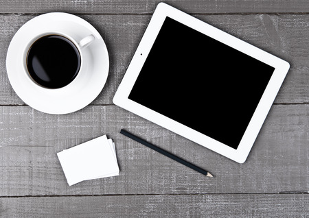 Graphic tablet with pencil paper cards and coffee on office deskの写真素材