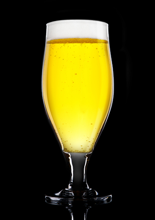 Glass of beer cider with foam golden color on black backgroundの写真素材