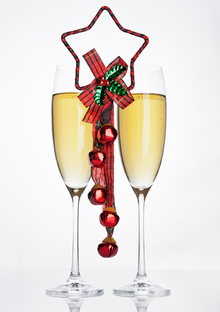 Glasses of sparkling champagne with christmas decoration on white backgroundの写真素材