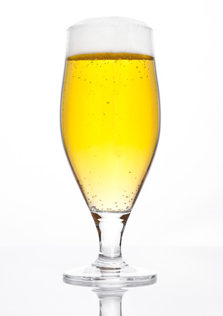Glass of beer cider with foam golden color on white backgroundの写真素材